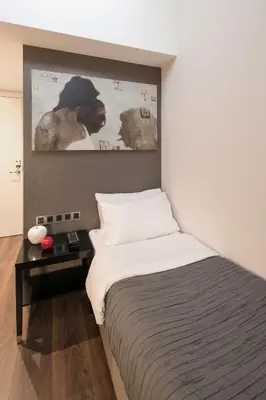 a bedroom with a bed and a picture on the wall at Quentin Prague Hotel in Prague