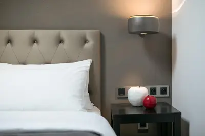 a bedroom with a bed and a table with an apple on it at Quentin Prague Hotel in Prague