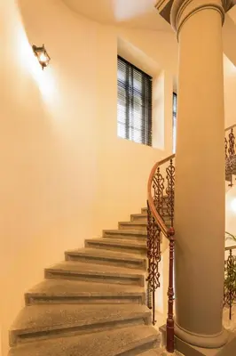 a staircase in a house with a column at Quentin Prague Hotel in Prague