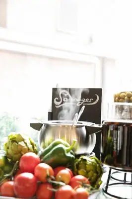 a pile of vegetables on a counter with a pot at Quentin Prague Hotel in Prague