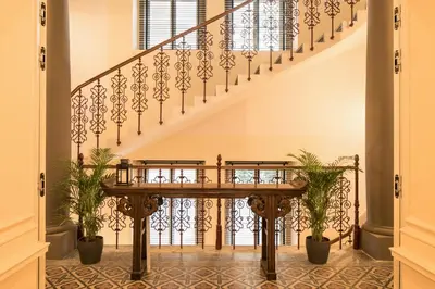 a staircase with wrought iron railings and potted plants at Quentin Prague Hotel in Prague
