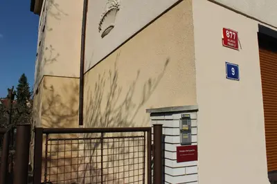 a building with a gate and a sign on it at Pension Hanspaulka in Prague