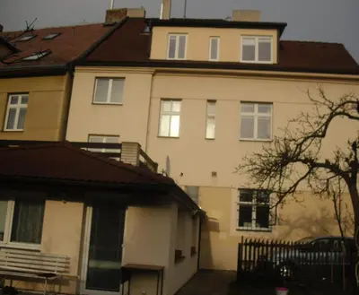a large white house with a brown roof at Pension Hanspaulka in Prague