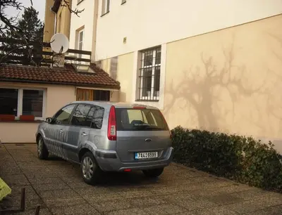 a silver van parked in front of a building at Pension Hanspaulka in Prague