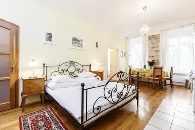 a bedroom with a bed and two red chairs at Prague Siesta Apartments in Prague