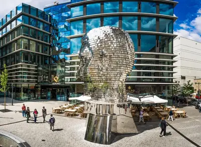 a statue of a head in front of a building at City Leaf Apartments in Prague