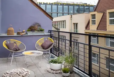 a balcony with two chairs and a table at City Leaf Apartments in Prague