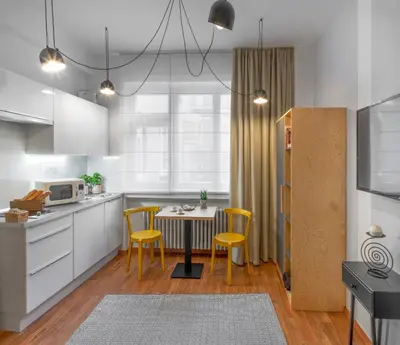 a kitchen with a table and yellow chairs in it at City Leaf Apartments in Prague