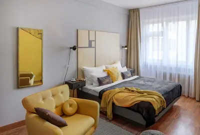 a hotel room with a bed and a chair at City Leaf Apartments in Prague