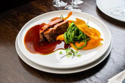 a plate of food with meat and vegetables on a table at Hotel Dvur Hoffmeister in Velké Číčovice