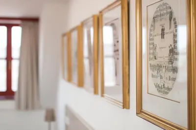 a row of framed pictures on a wall at Hotel Dvur Hoffmeister in Velké Číčovice
