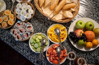 a table with plates of food and bowls of fruit at Hotel Dvur Hoffmeister in Velké Číčovice