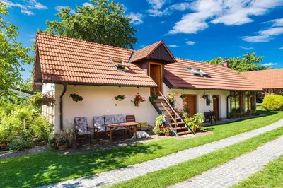 a cottage with a table and chairs in a yard at Tradiční český dům s ložnicemi v podkroví in Všejany