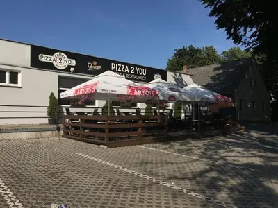a building with tables and umbrellas in front of a building at Tradiční český dům s ložnicemi v podkroví in Všejany