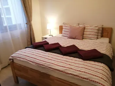a large bed with red and white pillows on it at Prima Family Apartments in Prague