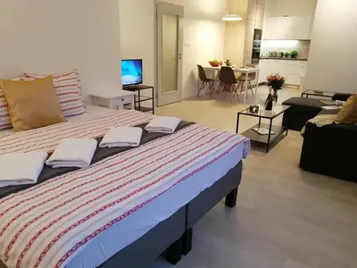 a bedroom with a large bed and a living room at Prima Family Apartments in Prague