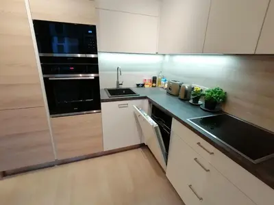 a kitchen with white cabinets and black appliances at Prima Family Apartments in Prague