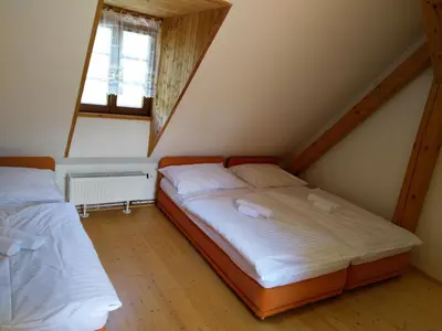 a bedroom with two beds and a window at Žabonosy Mlýn in Žabonosy