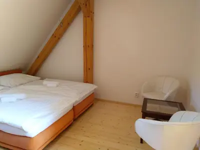 a bedroom with a bed and a chair and a table at Žabonosy Mlýn in Žabonosy