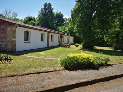a small white house with a grass yard at Green Apartments in Luštěnice