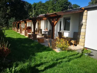 a pergola on the side of a house at Green Apartments in Luštěnice