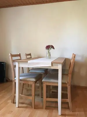 a white table with chairs and a vase with flowers at U Pichlerů in Klipec