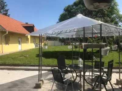 a table and chairs under a tent in a yard at U Pichlerů in Klipec
