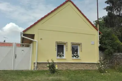a yellow house with two windows and a fence at U Pichlerů in Klipec