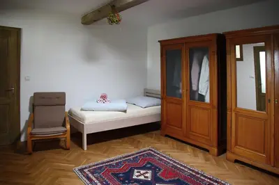 a room with a bed and a cabinet and a rug at Ubytování na statku in Vědomice