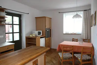a kitchen with a table with chairs and a microwave at Ubytování na statku in Vědomice