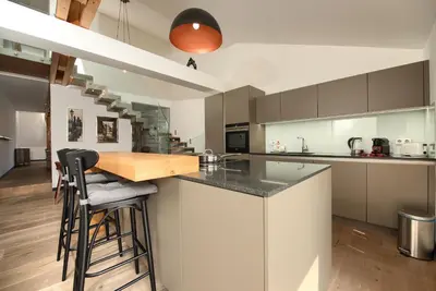 a kitchen with a counter and some stools in it at Kolkovna 5 Penthouse in Prague