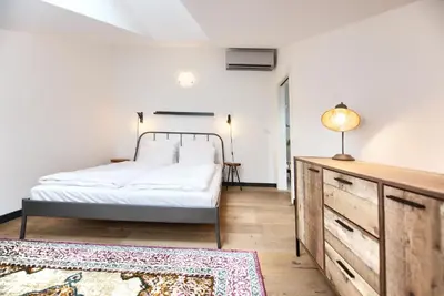 a bedroom with a bed and a dresser and a rug at Kolkovna 5 Penthouse in Prague