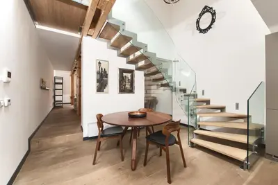 a dining room with a table and a staircase at Kolkovna 5 Penthouse in Prague