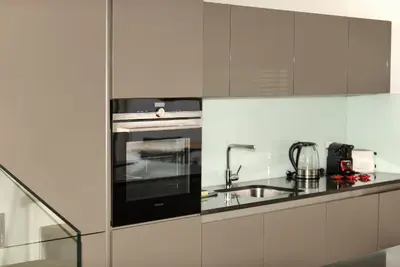 a white kitchen with a sink and a stove at Kolkovna 5 Penthouse in Prague