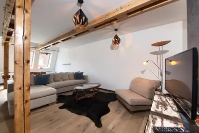 a living room with a couch and a tv at Kolkovna 5 Penthouse in Prague