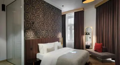 a hotel room with a bed and a chair at Mottl House by Adrez in Prague