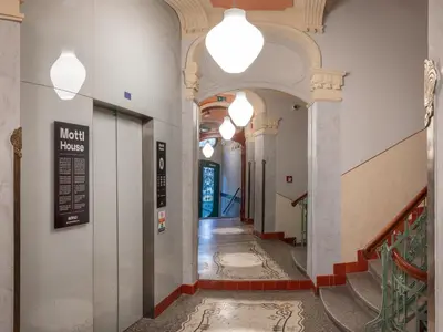 a hallway of a building with a staircase and lights at Mottl House by Adrez in Prague