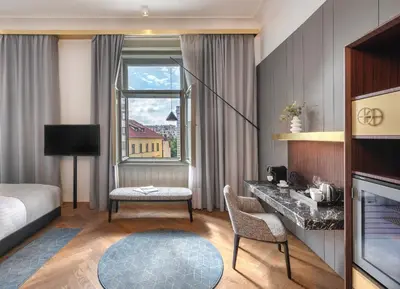a hotel room with a bed and a desk and a window at Mottl House by Adrez in Prague