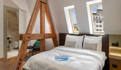 a bedroom with a large bed with a wooden ladder at Mottl House by Adrez in Prague
