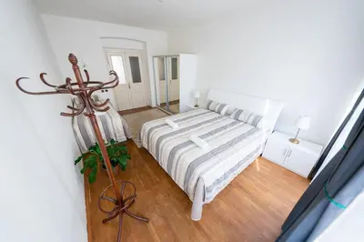 a white bedroom with a bed and a mirror at 6 Bob's Apartments - 3 bedrooms, King size beds in Prague