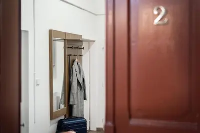 a hallway with a door and a mirror and a suitcase at Prague - Karlin Apartments in Prague