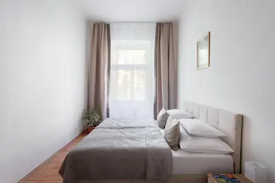 a bedroom with a blue bed and a window at Prague - Karlin Apartments in Prague