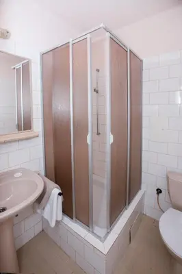 a bathroom with a shower and a sink and a toilet at Hotel-Pension KAMÝK in Prague