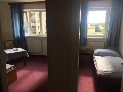 a small bedroom with a bed and a window at Hotel-Pension KAMÝK in Prague