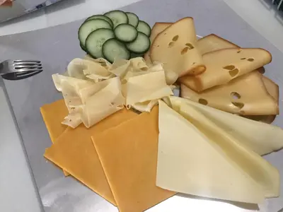 a plate of cheese and other foods on a table at Hotel-Pension KAMÝK in Prague