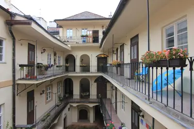 an alleyway between two buildings with flowerpots on balconies at Mala Strana apartment 1 in Prague