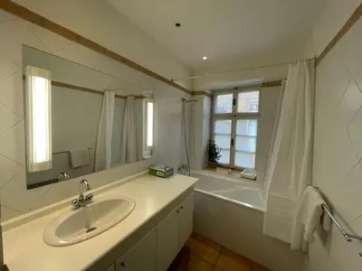 a bathroom with a sink and a mirror and a tub at Mala Strana apartment 1 in Prague