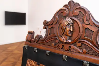 a wooden bed with a carving of a head on it at Arch III at Wenceslas in Prague