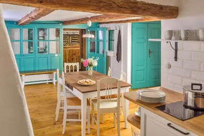 a kitchen with blue cabinets and a table and chairs at Homutův statek in Kokořín