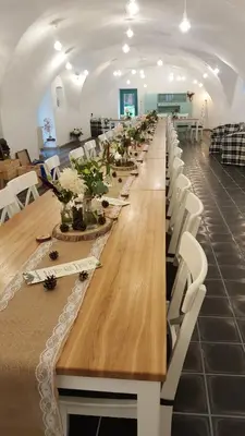 a long table in a room with white chairs at Homutův statek in Kokořín